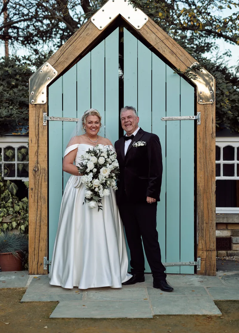 Couple at the pastel blue beach-hut door at Friern Manor