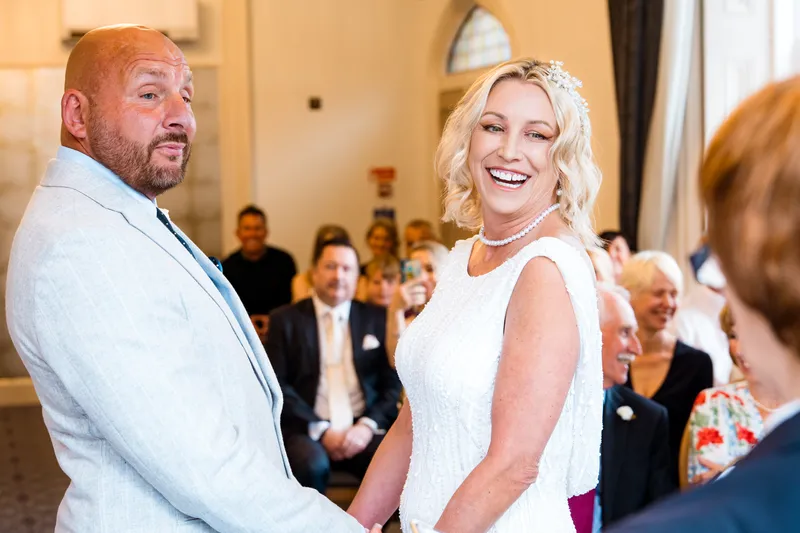 Bride and groom laughing during the ceremony at Oakwood House
