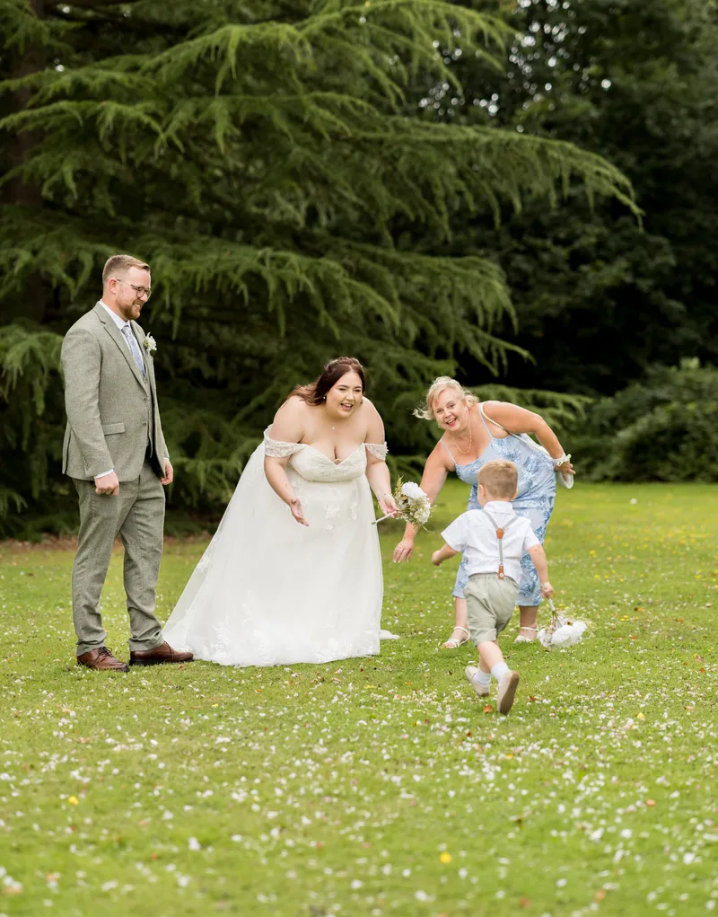 Couple playing with a child on the lawn at Oakwood House