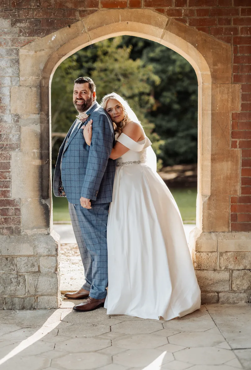 Bride and groom embracing in the brick arch at Oakwood House