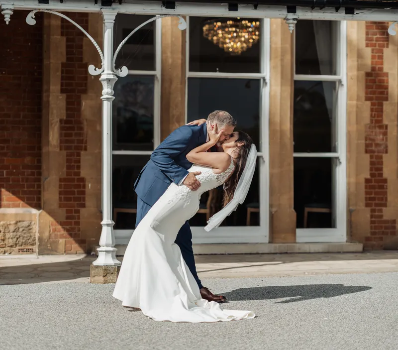 Groom dipping the bride for a kiss outside Oakwood House