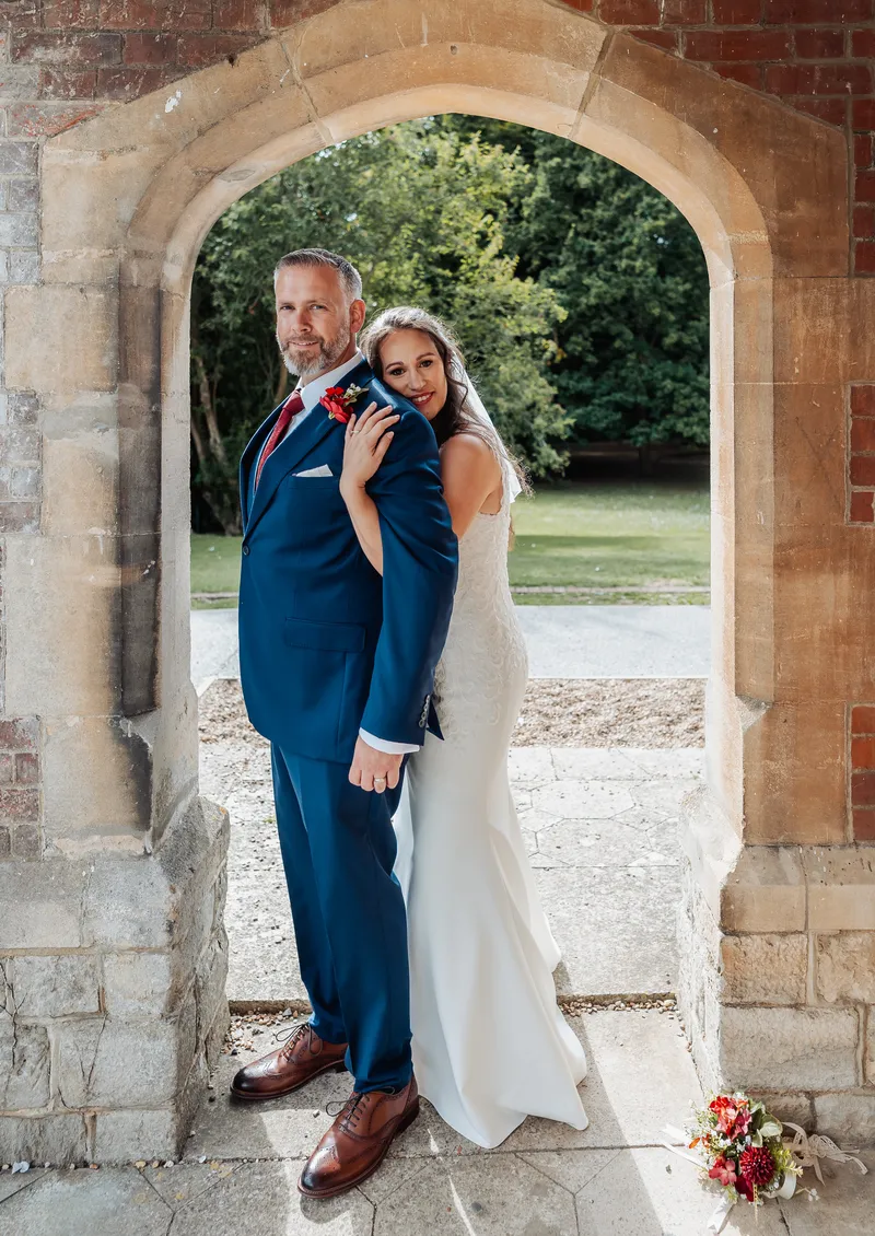 Couple portrait in the arch overlooking the gardens at Oakwood House