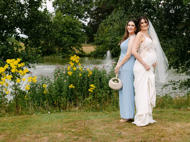 Bride and bridesmaid by the lake at Chilston Park