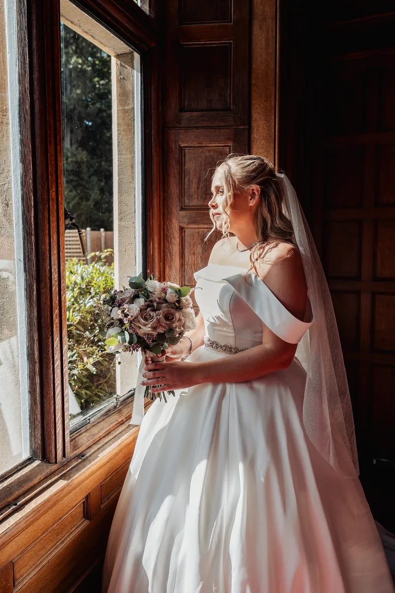 Bride by the window before the ceremony at Oakwood House