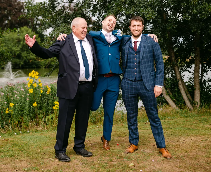 Groom with family by the lake at Chilston Park