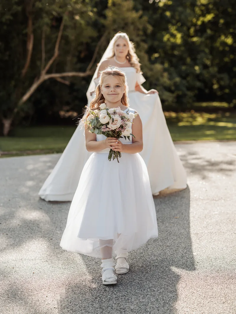 Flower girl walking ahead of the bride at Oakwood House