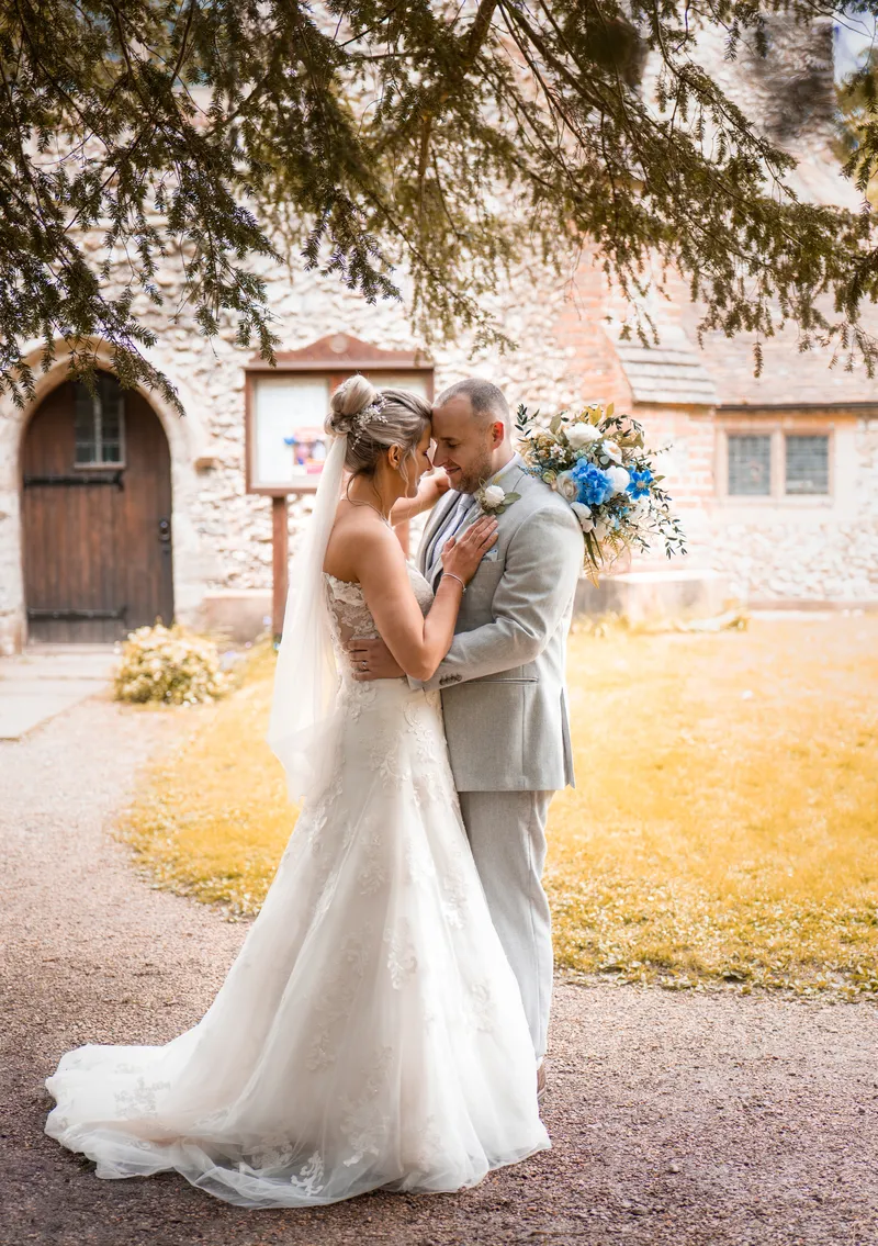 Couple embracing in golden light outside a church