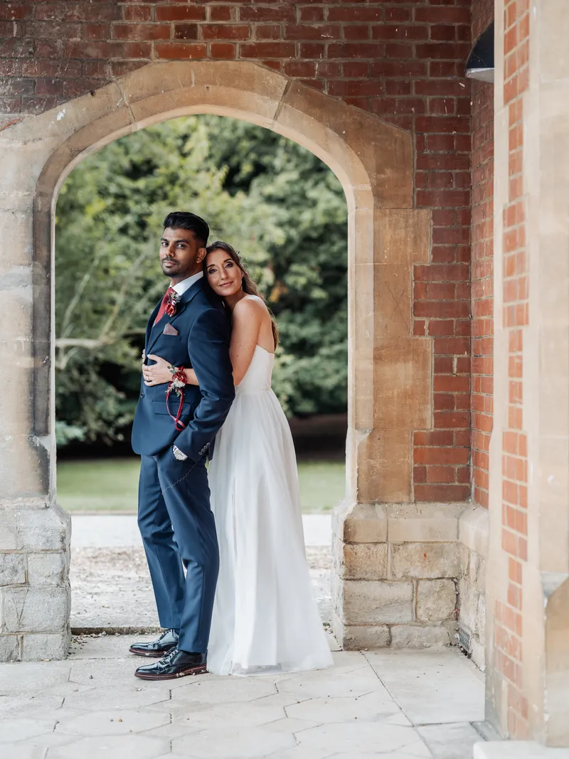 Couple portrait framed by the brick arch at Oakwood House