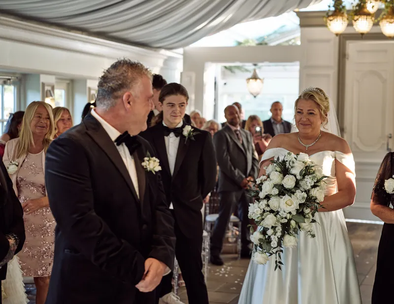 Bride and groom walking back up the aisle at Friern Manor