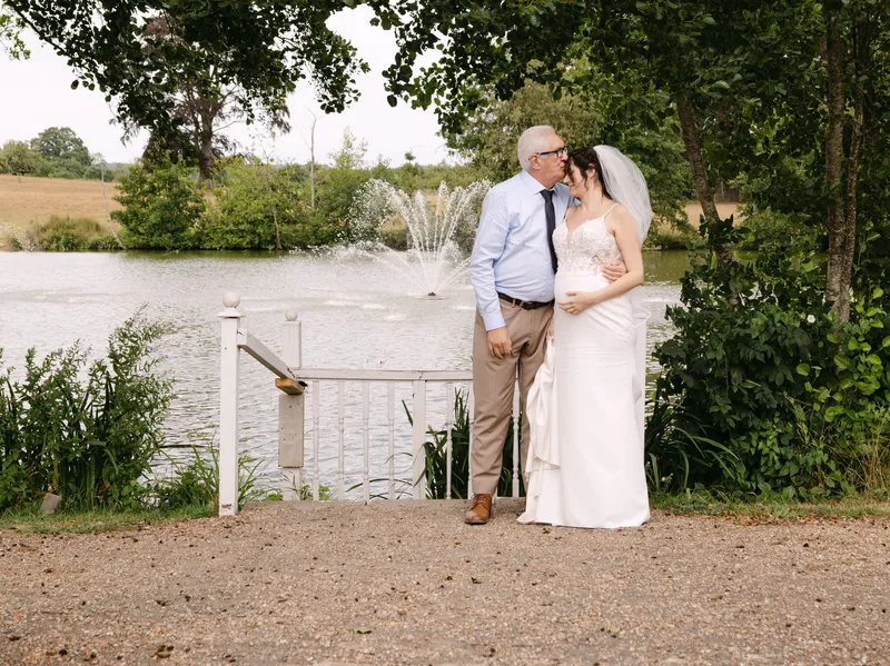 Bride with her father by the lake at Chilston Park