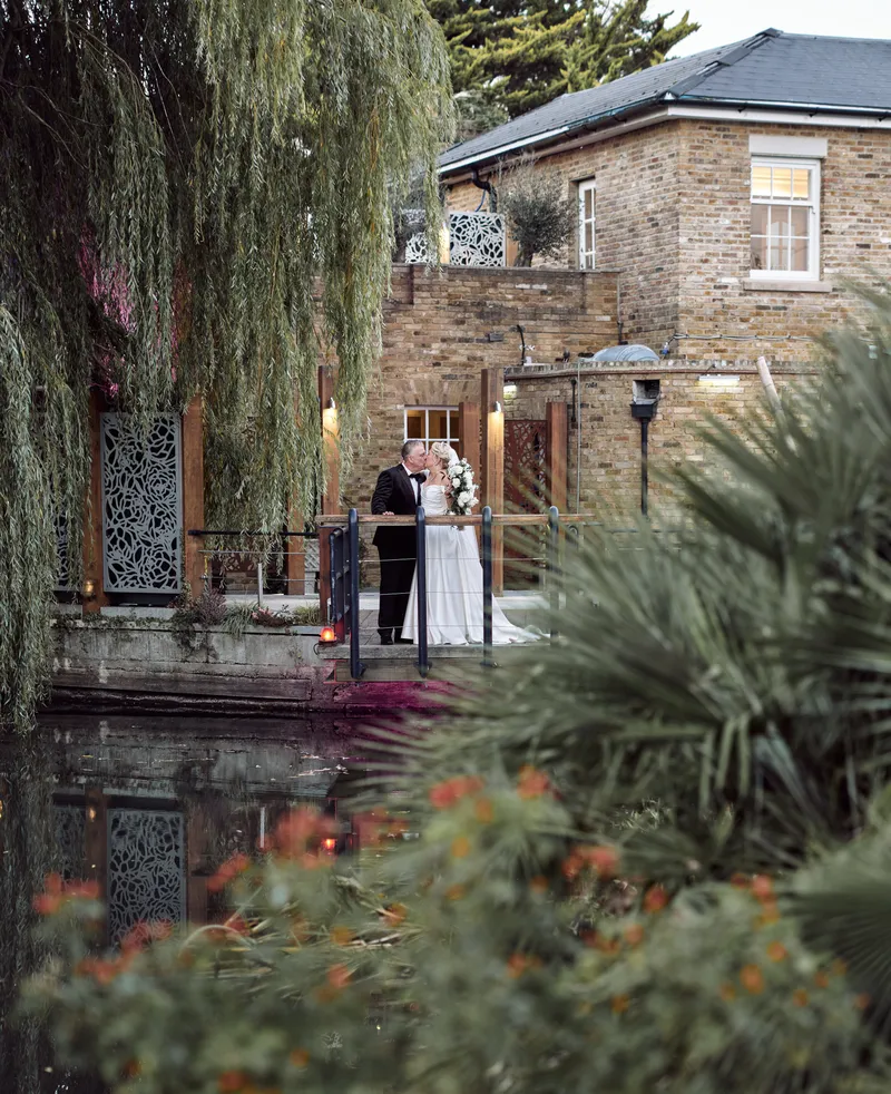 Couple by the water in the gardens at Friern Manor