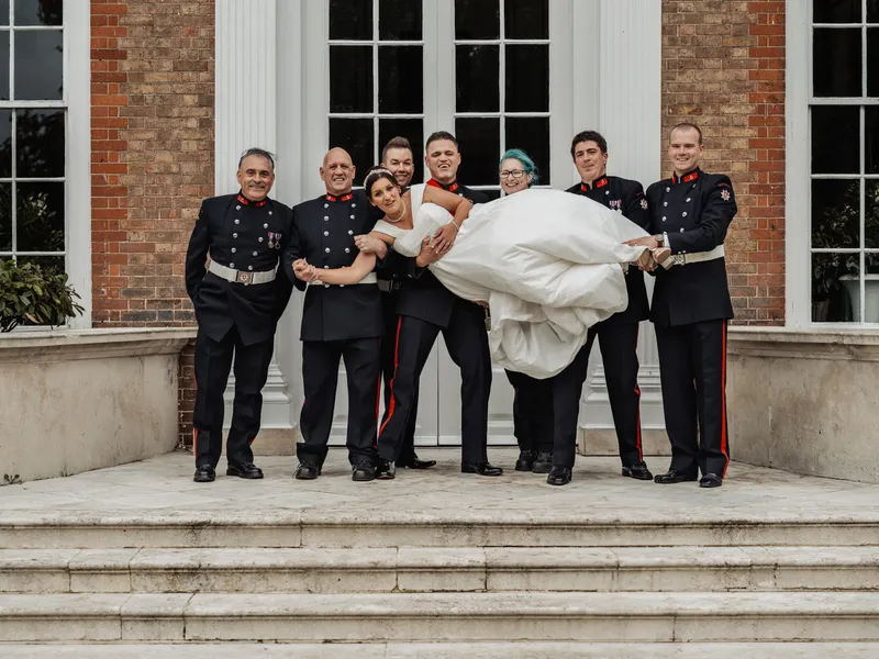 Firefighters in dress uniform lifting the bride on the steps at Bradbourne House