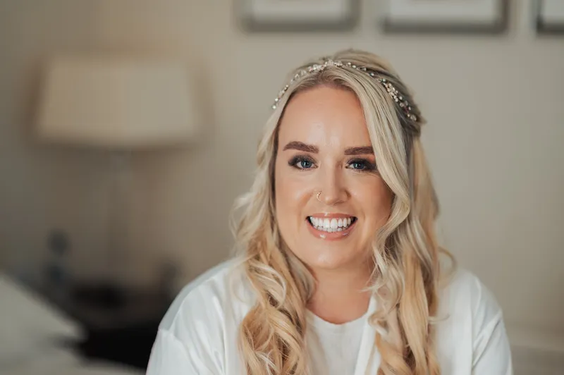 Bride smiling in her robe on the wedding morning