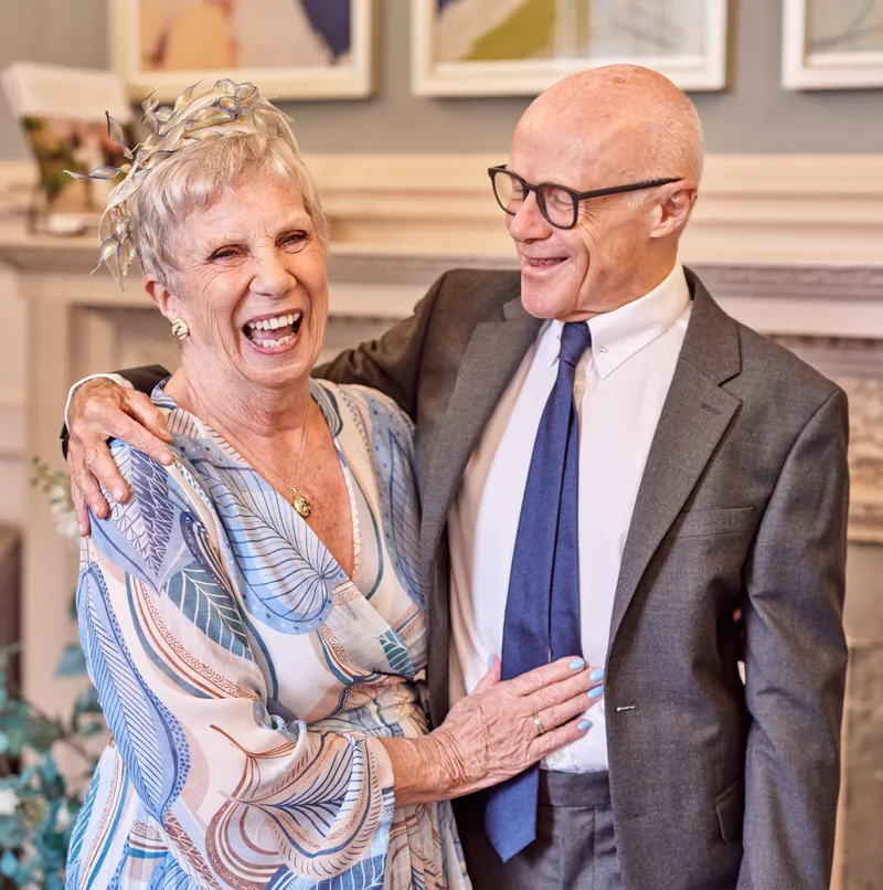 Wedding guests laughing together in a fireside room