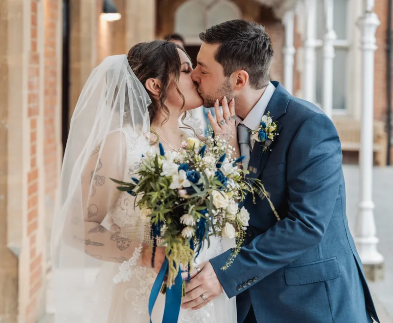Couple kissing under the veranda at Oakwood House, Maidstone