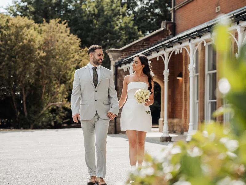 Couple walking hand in hand past the veranda at Oakwood House, Maidstone
