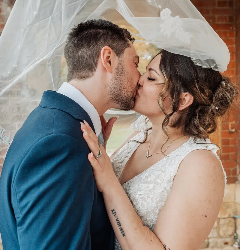Couple kissing under the veil at Oakwood House