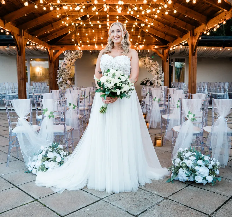 Bride under the festoon-lit Water Terrace at The Orchard, Bearsted