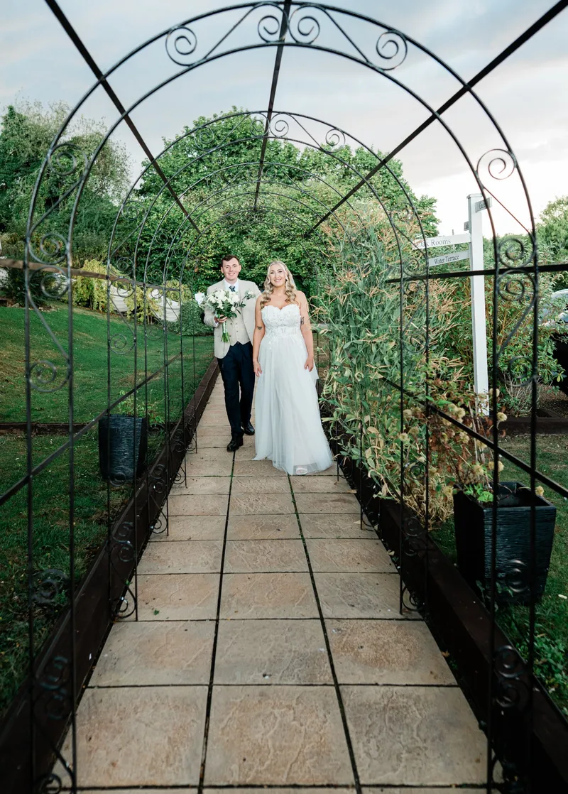 Couple walking under the metal arch walkway at The Orchard